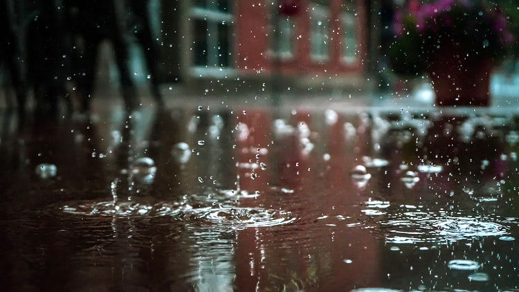 Foto: regn som droppar rött hus i bakgrunden